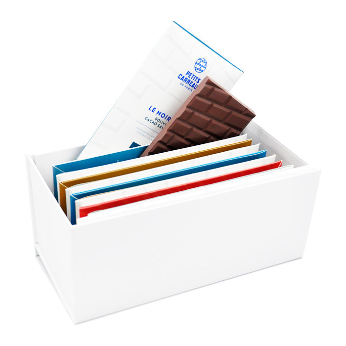 Coffret personnalisable ouvert avec 10 tablettes de chocolat artisanal bien rangées, un étui et une tablette sortant du coffret, Petits Carreaux de Paris