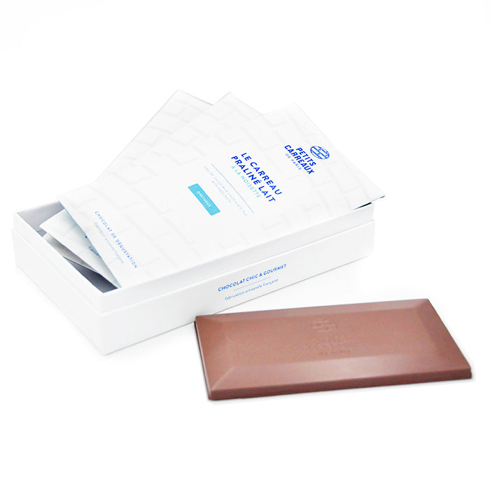 Coffret personnalisable ouvert avec 2 étuis de tablettes et 1 étui de carreau praliné, carreau praliné posé au pied du coffret, Petits Carreaux de Paris